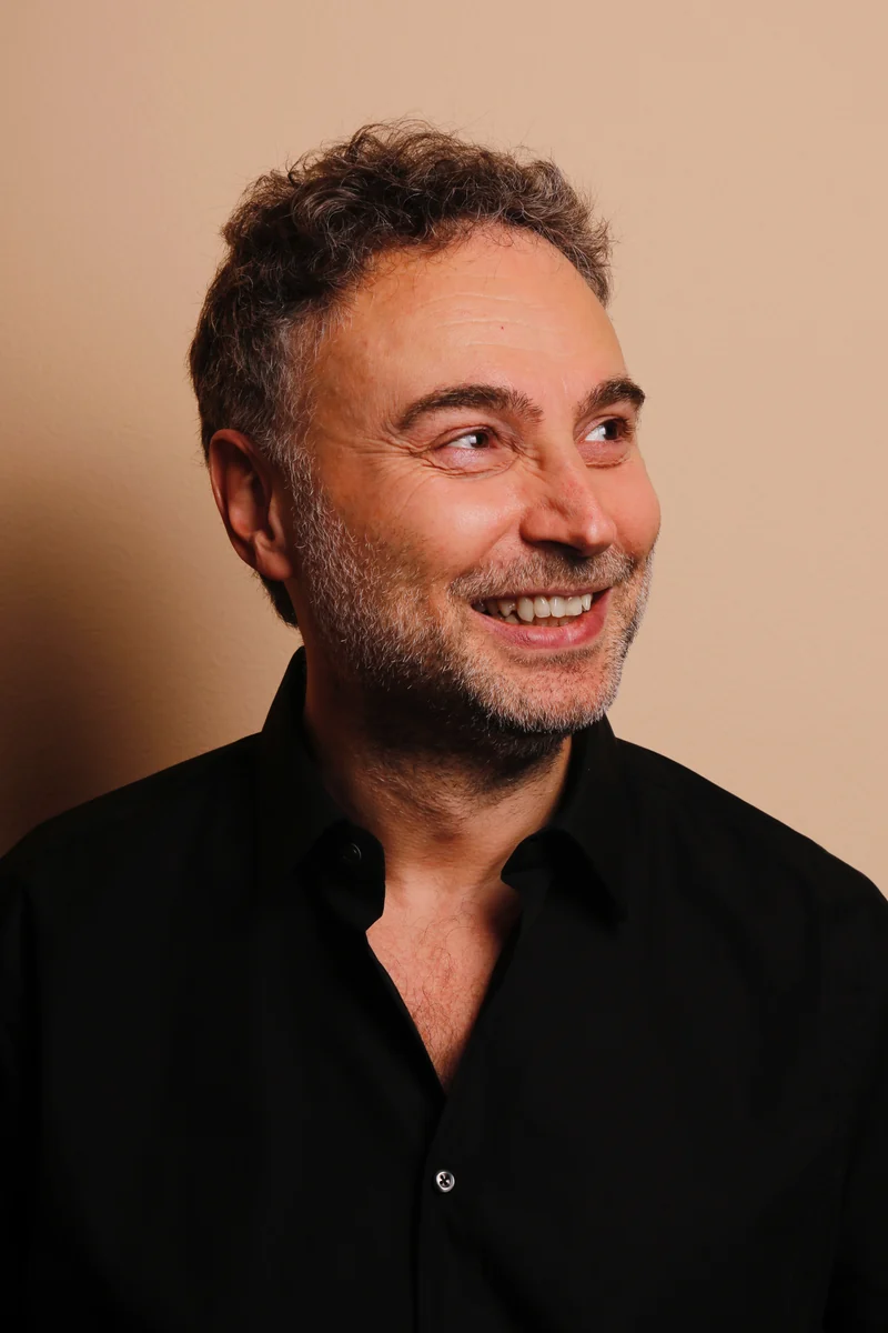 Jürgen Birlinger in einem warmen Farbporträt, lächelnd mit Blick zur Seite